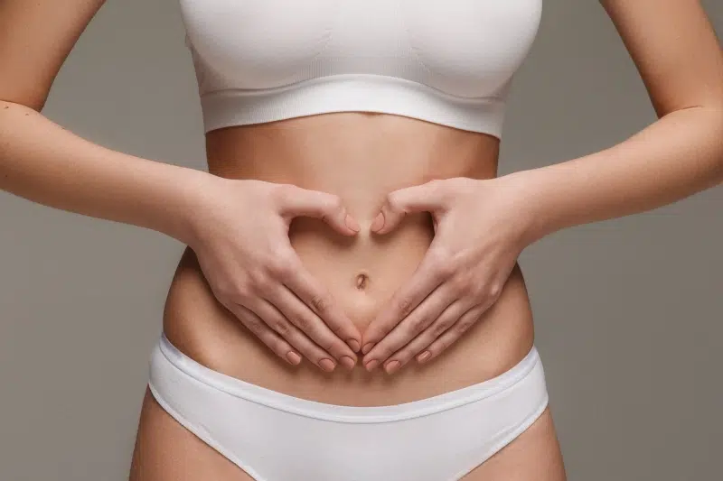 darmreinigung-gewichtsverlust Frau in Unterwäsche formt Herz mit den Händen über dem Bauch – Symbol für Darmgesundheit, Darmsanierung und Unterstützung beim Gewichtsverlust.